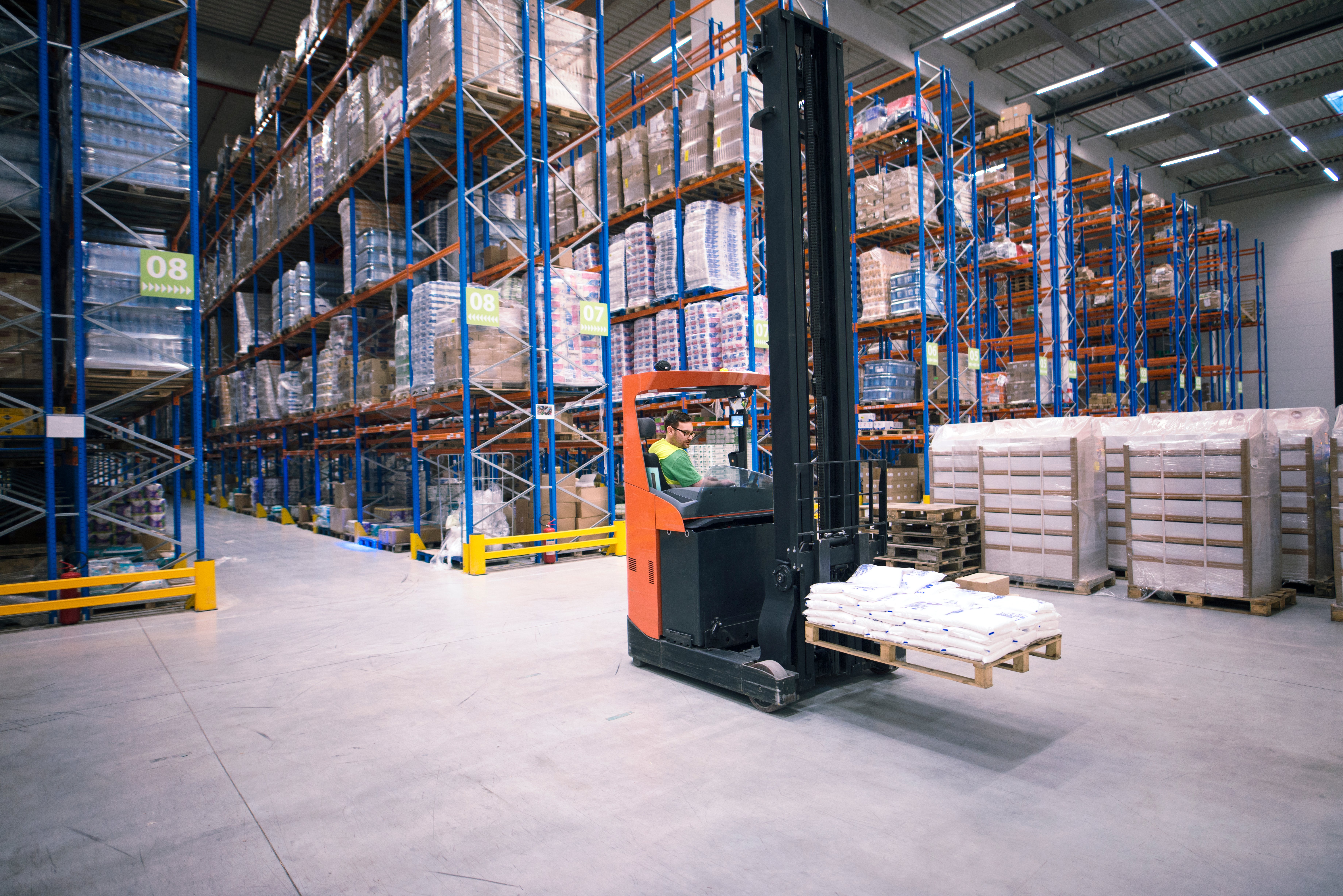 worker-operating-forklift-machine-relocating-goods-large-warehouse-center